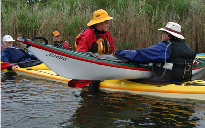 Students learning to repair a boat while on the water